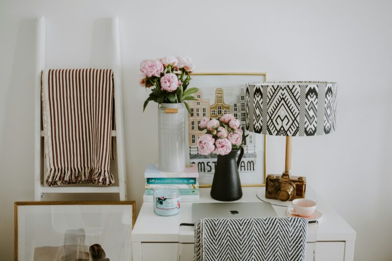Cosy home office setup with pretty lamp and fresh flowers on desk
